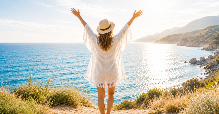 woman standing one cliff admiring the ocean